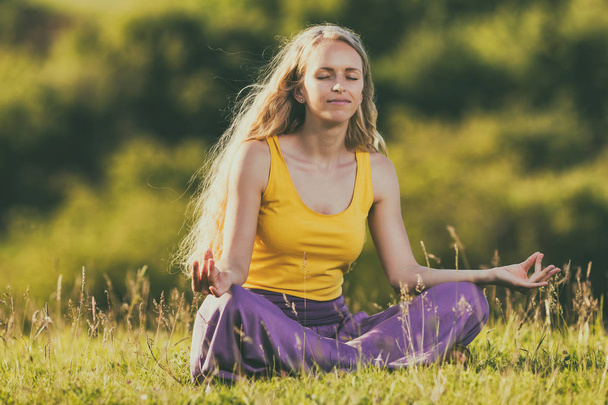 Жінка медитує на лузі
 - Фото, зображення