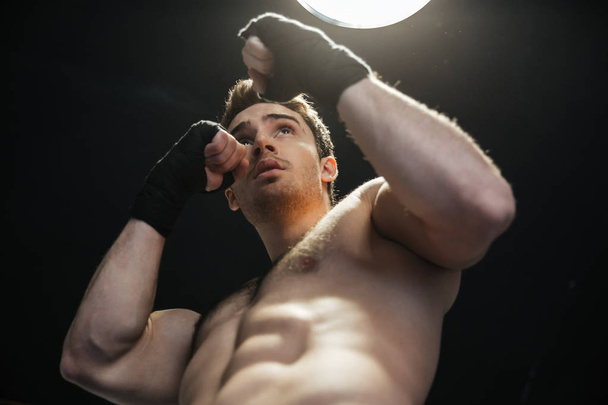 Low view of sportsman wearing gloves and boxing - Valokuva, kuva