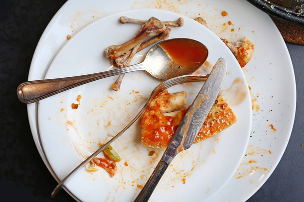 Food waste, piece of pizza remains on plate - 写真・画像