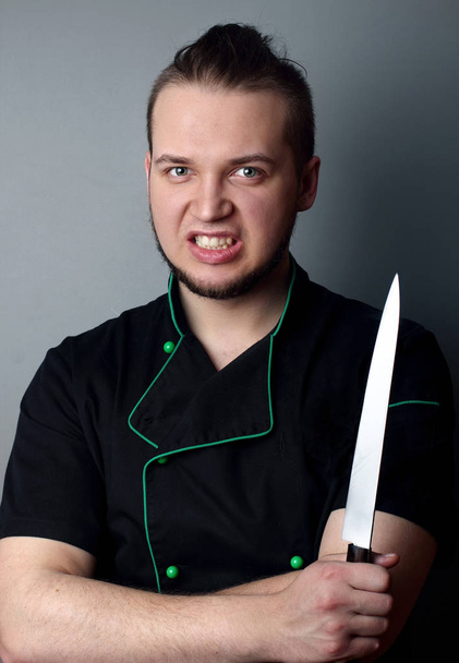 Angry chef with knife on gray bakcground.Chef.Portrait - Photo, Image