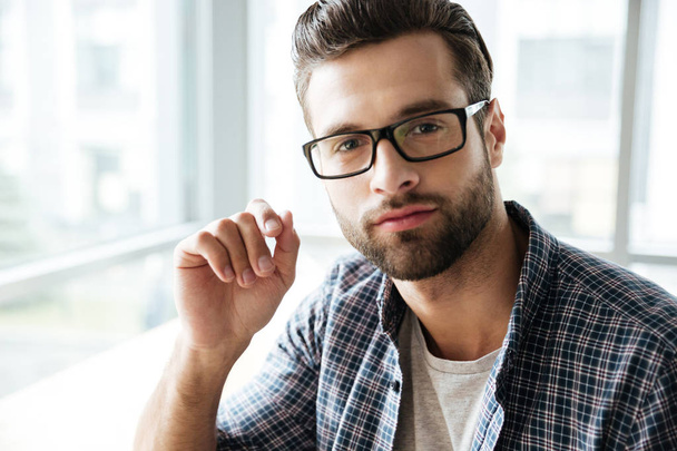 Handsome man wearing glasses sitting in office coworking - Foto, afbeelding