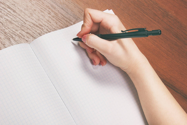 Notebook and pen in hand. Isolated on white background. - Valokuva, kuva