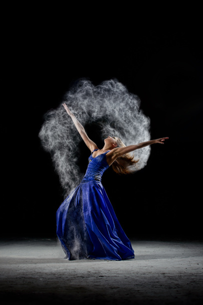 Taniec dziewczyna w ciemności, zrobić sztuki performance z białym pyłem chmury. - Zdjęcie, obraz