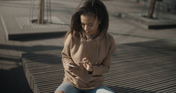 Portrait of young African American woman using phone, outdoors. - Foto, Imagen