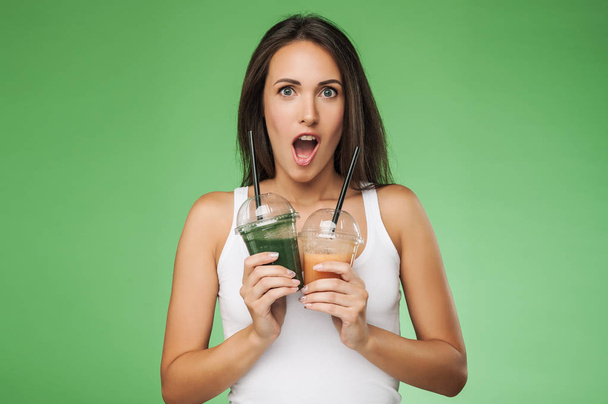 Young surprised woman holding smoothie - Valokuva, kuva