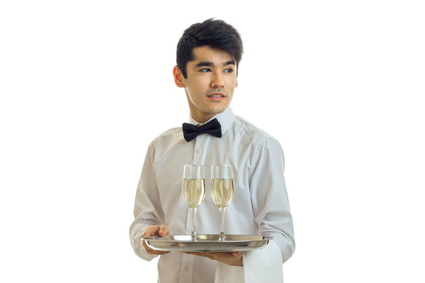 lindo camarero joven se para desenroscar mi cabeza a un lado y sosteniendo una bandeja con copas de champán
 - Foto, imagen