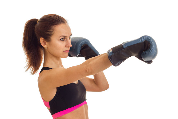 a young girl with the ponytail looks toward and reaches out his hands forward in boxing gloves - Foto, Imagem