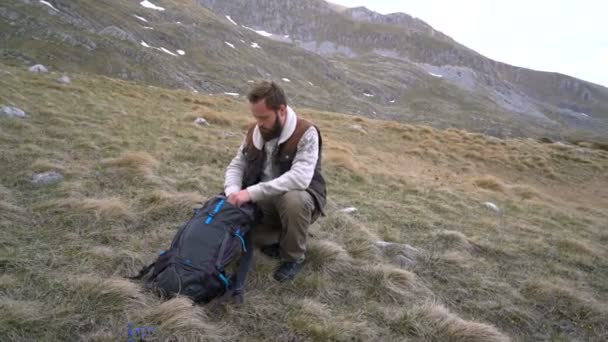 Hiker sits and drinks hot tea from a thermos - Πλάνα, βίντεο