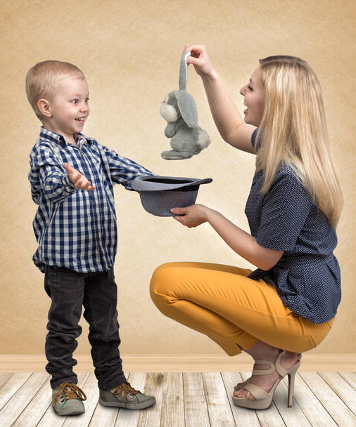 Tricks with a rabbit.A young mother shows little boy magic tricks rabbit in the hat.Family friendly,entertainment. - Fotoğraf, Görsel