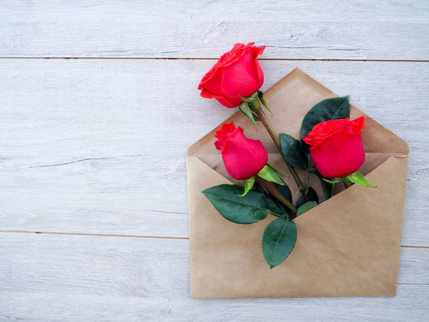 kirjekuori Kraft paperi, kukkia punaisia ruusuja puupohjalla, tilaa tekstiä, kuten onnittelut häät, syntymäpäivä
 - Valokuva, kuva