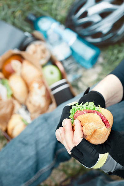 Nahaufnahme von Menschenhänden mit Sandwich beim Picknick - Foto, Bild