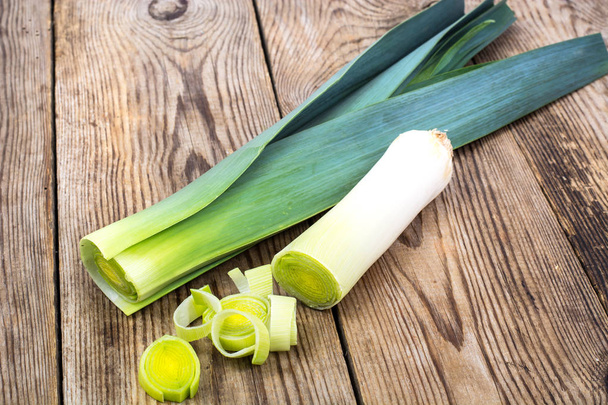 Leek, cut into pieces, on an old wooden table - Photo, Image