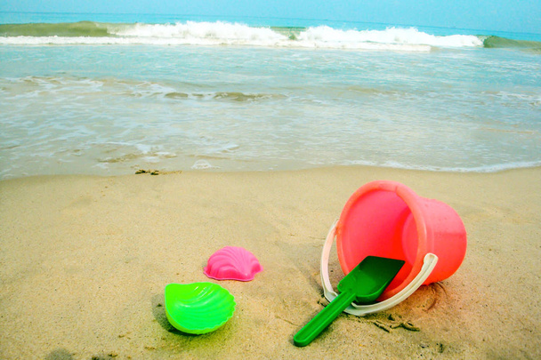 Lasten sanko ja värilliset muotit rannalla hiekassa
 - Valokuva, kuva