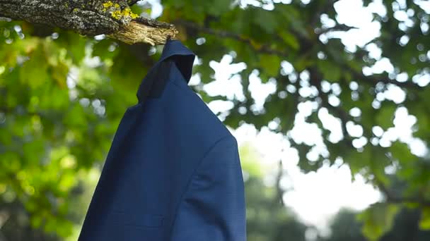 Traje masculino colgando en el parque de ramas de árbol en verano
 - Imágenes, Vídeo