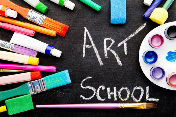 Escuela de Arte - escrito a mano en pizarra rodeado de equipos de arte
 - Foto, imagen