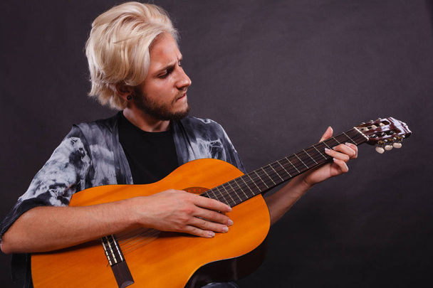 Blonde man playing acoustic guitar - Фото, зображення