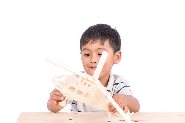 Симпатичный азиатский маленький мальчик играет самолет дерево игрушки
 - Фото, изображение