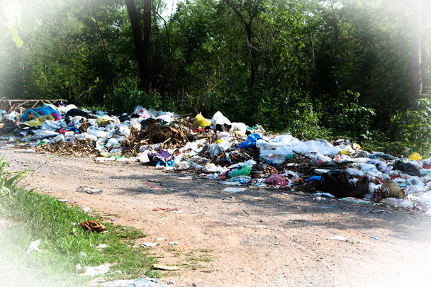 Купа побутового сміття біля сільської дороги на природі
 - Фото, зображення