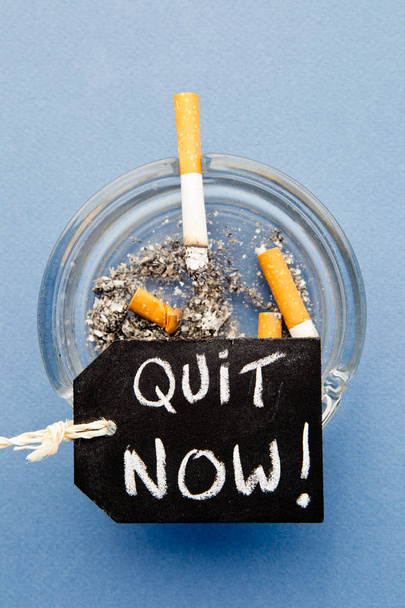 Σταματήσουν το κάπνισμα - Κλείστε τώρα - με τσιγάρα, τασάκι και μαυροπίνακα σε μπλε φόντο - Φωτογραφία, εικόνα