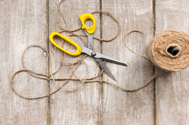 Scissors and rope on wooden background. - 写真・画像