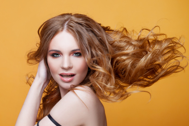 Mutlu güzel kızıl saçlı kız lüks kıvırcık saçlı. Stüdyo portre Sarı zemin üzerine. Mükemmel saç - Fotoğraf, Görsel
