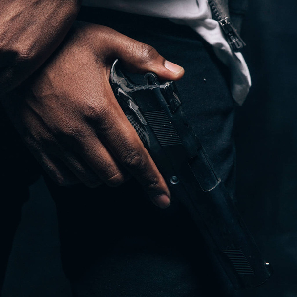Unrecognizable armed black criminal man closeup - Foto, afbeelding