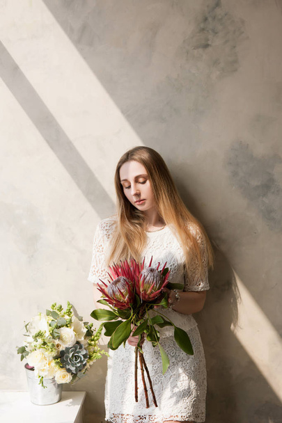 Woman with bouquet of big rare flowers - Foto, afbeelding
