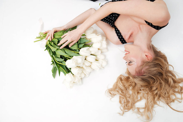 Top view of woman lying on floor with flowers - Foto, Imagen