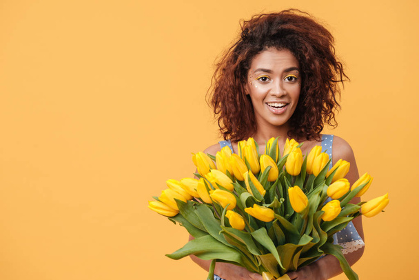 Surprised African woman holding bouquet of flowers - Foto, Bild
