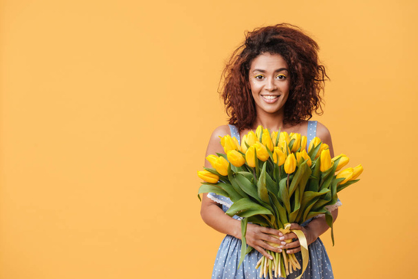 Pretty African woman holding bouquet of flowers - Foto, immagini