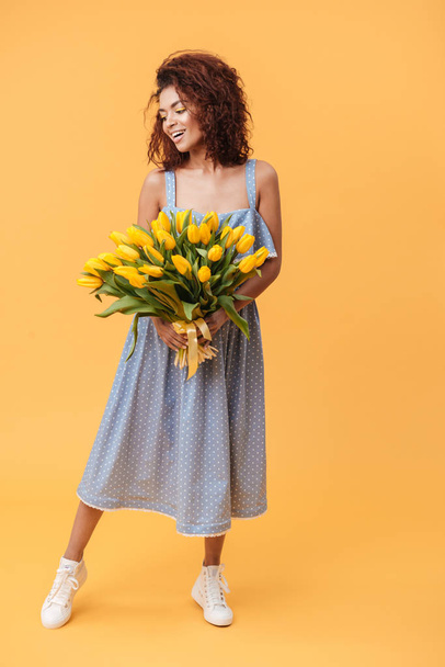 Full-length portrait of Smiling African woman holding bouquet  f - Foto, afbeelding