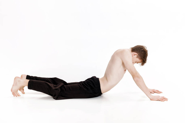 Young man doing yoga exercises. Studio shot on white background - Photo, Image