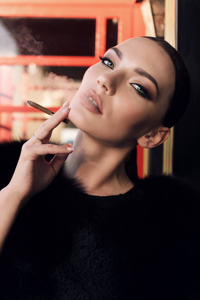 gorgeous sexy woman with dark hair in elegant outfit smoking cig - Zdjęcie, obraz