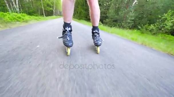 Backwards inline skating and braking on the asphalt. Close up view to move man legs and slow down. Easy backwards ride and slowing down. - Footage, Video