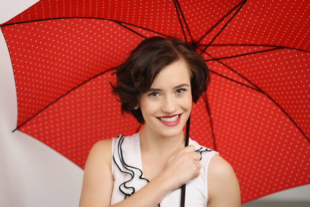 Hermosa joven con un paraguas rojo
 - Foto, imagen