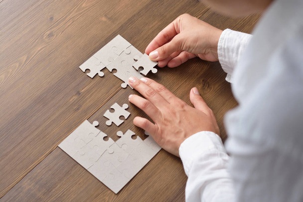 Image of businesswoman connecting elements of white puzzle - Фото, изображение