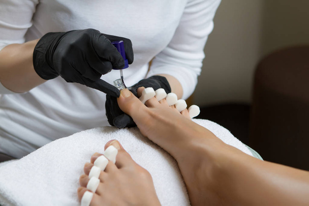 Pedicure at the beauty salon nail polish fixative lacquer woman  - Фото, изображение