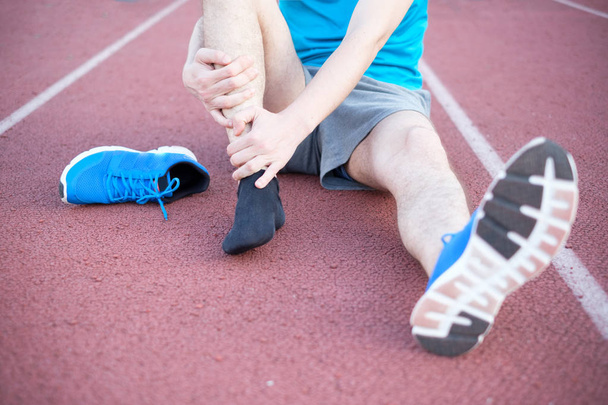 Running athlete feeling pain because of injured ankle - Photo, Image