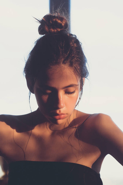girl with bun and oily or wet face skin - Foto, afbeelding