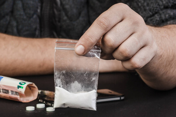 Drogenabhängige oder Drogendealer mit einem Päckchen Heroin oder Koka - Foto, Bild