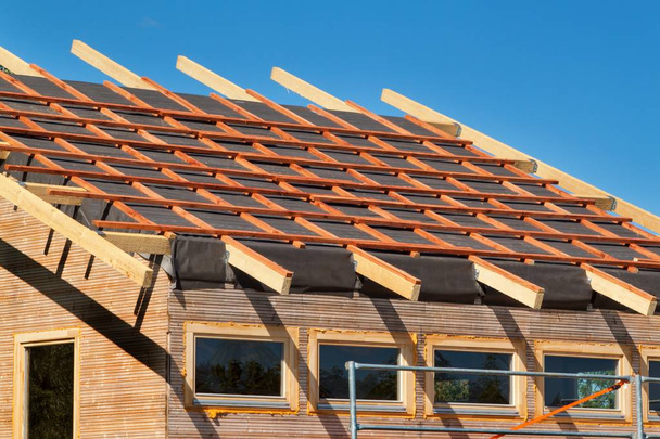 Construction d'un toit en bois dans une maison écologique. Travaux externes sur l'enveloppe du bâtiment. La structure en bois de la maison près de la forêt
. - Photo, image