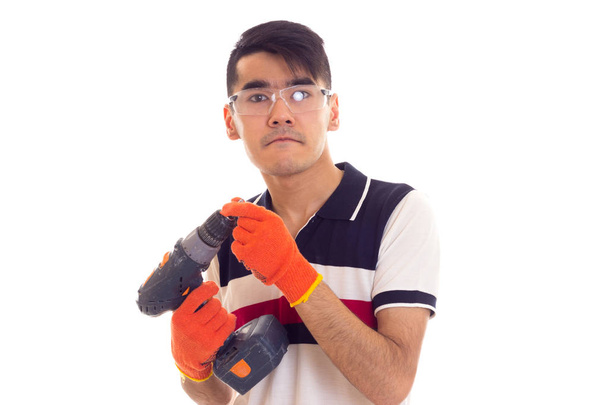 Młody człowiek z rękawice i okulary gospodarstwa Wkrętak elektryczny - Zdjęcie, obraz