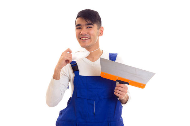 Man in blue overall with respirator holding spatula - Фото, зображення