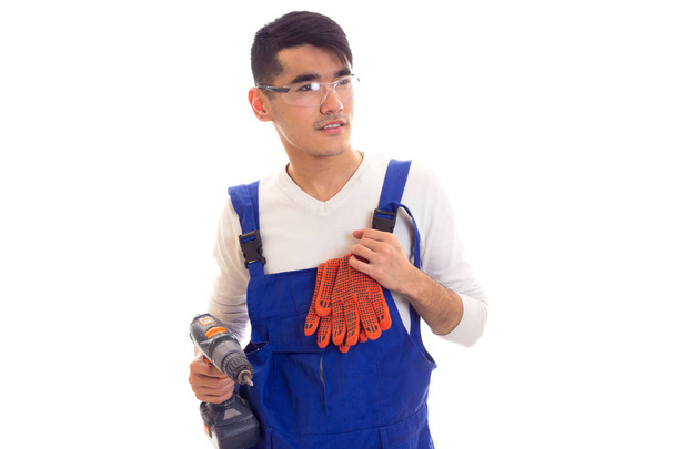 Man in overall with gloves and glasses holding electric screwdriver - Photo, Image