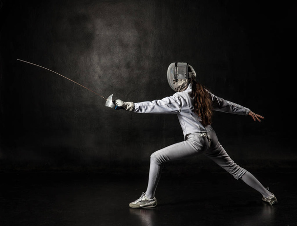 Female fencer isolated on black background - Valokuva, kuva