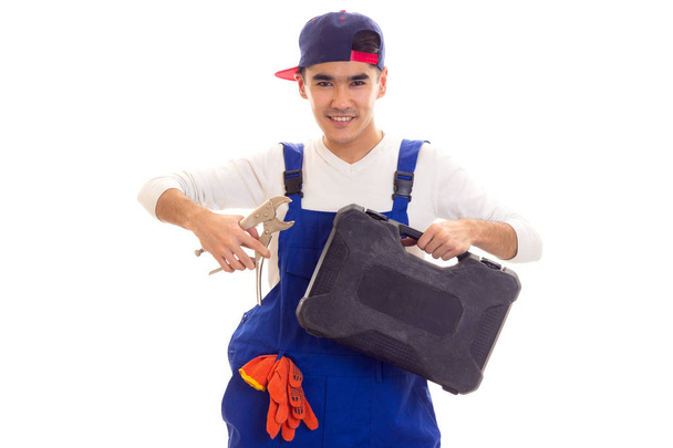 Junger Mann hält Schraubenschlüssel und Werkzeugkiste - Foto, Bild
