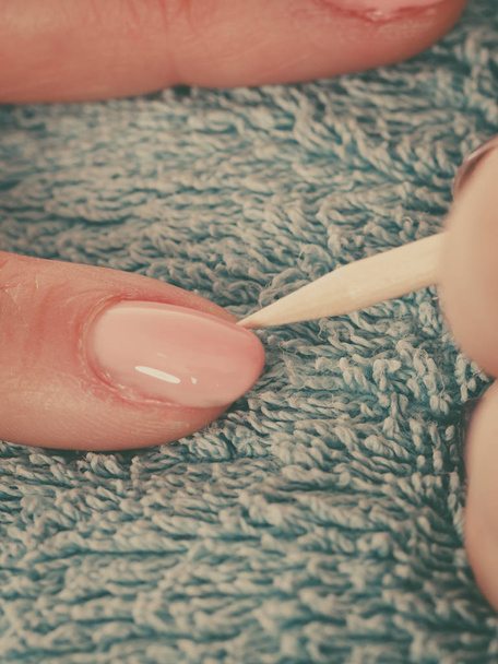 esteticista preparando las uñas antes de la manicura, empujando hacia atrás las cutículas
 - Foto, Imagen