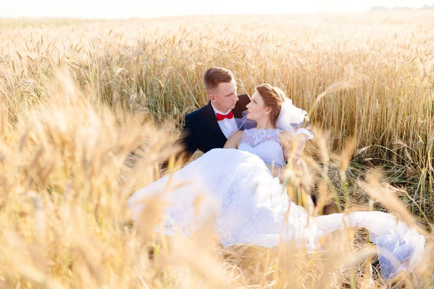 Recién casados posando en campo de grano
. - Foto, imagen