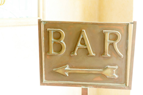 Wooden board with lettering Bar stands at the beige wall - Photo, image