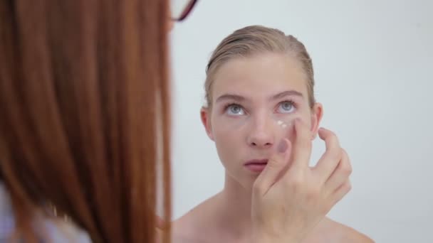 Professional make-up artist applying cream base eyeshadow primer to model eye - Footage, Video
